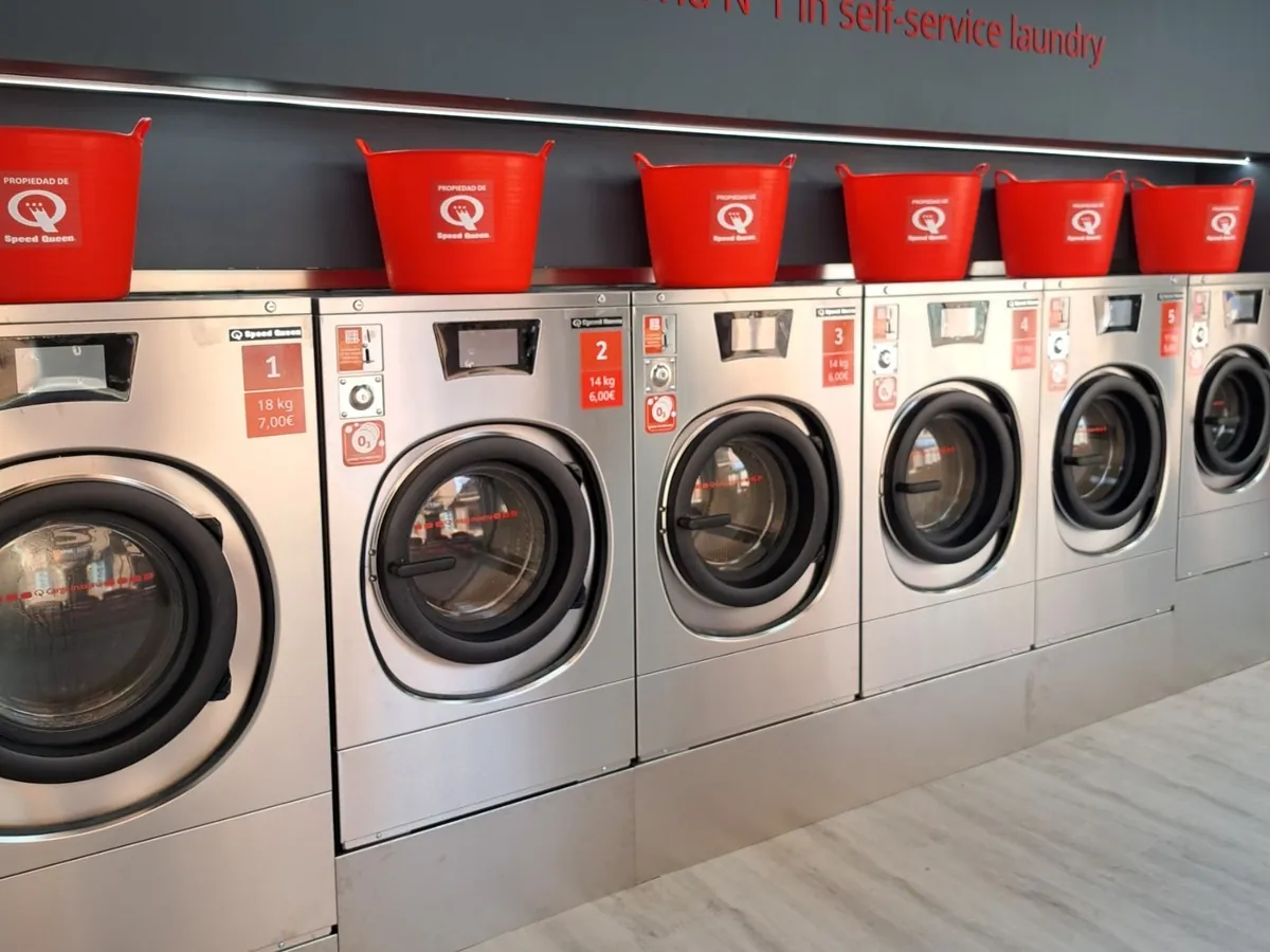 Rangée de lave-linge Speed Queen de différentes capacités dans une laverie Gira Gira